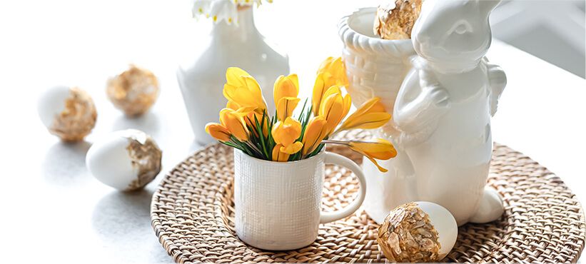 Tulips on table setting with festive Easter eggs and rabbit decoration.